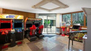 A room with arcade games including 'Time Chaser' and 'Super C'. - Sun City - Q Stay (Surfers Paradise)