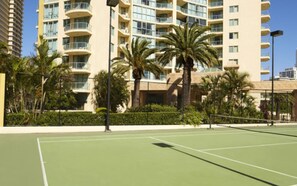 Una cancha de tenis con un edificio al fondo.