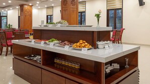 A buffet setup with various food items and a wooden decorative piece. - Convention Center Sapa Hotel (Sa Pa)