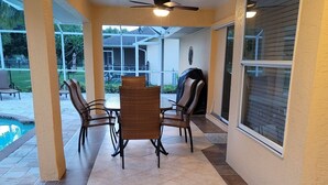 A covered patio area with a pool, outdoor furniture, and a ceiling fan. - ---BEAUTIFUL TROPICAL GARDEN HEATED POOL HOME ---
/AN OPTION BOAT RENTAL (Cape Coral)