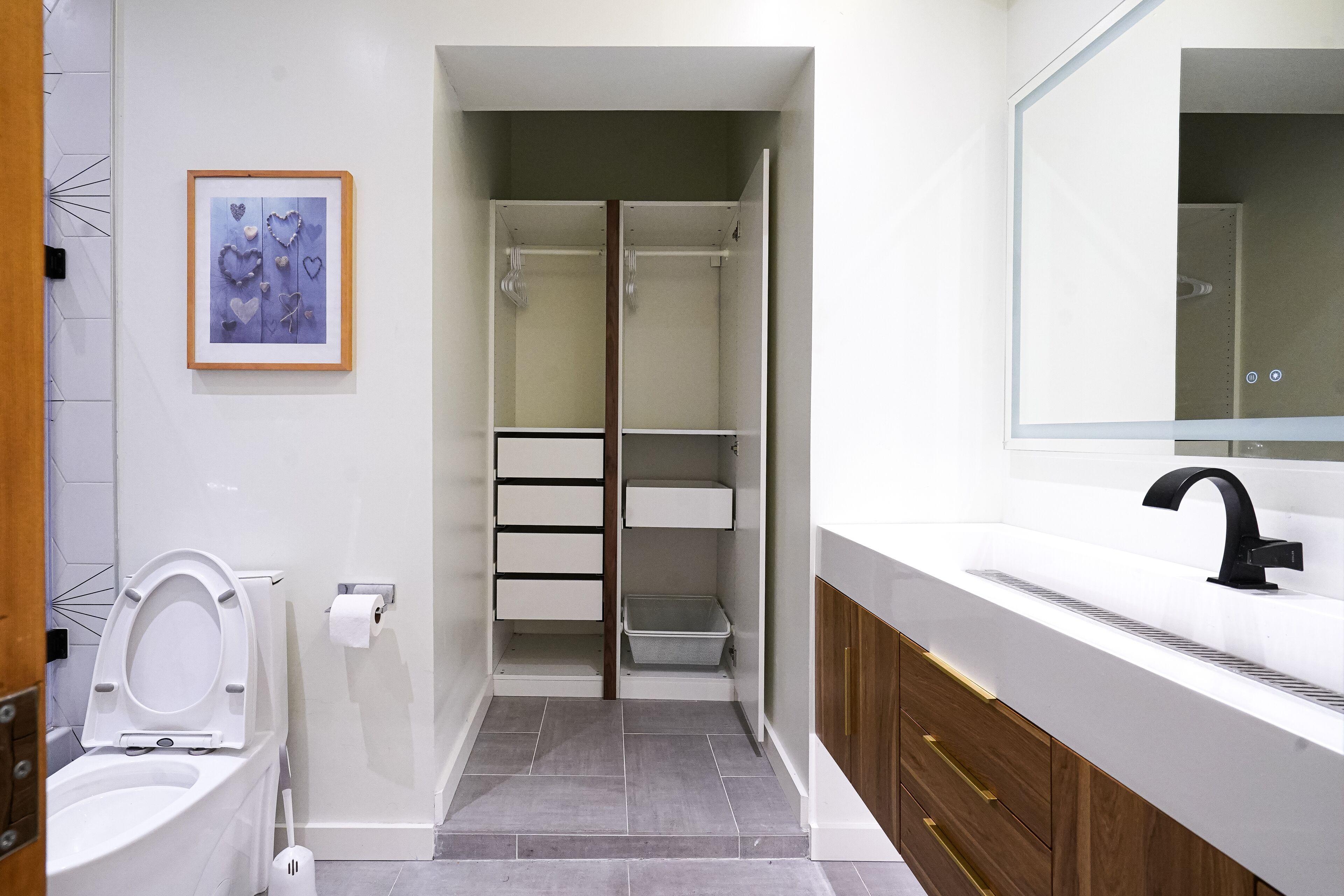 Un baño moderno con inodoro, lavabo y zona de ducha.