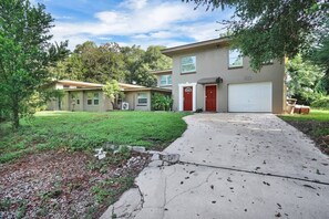 A two-story house with a garage, a front yard, and a driveway. - Smart Saver Townhouse, Family Friendly, Close to NAS Jax, Long-Term, Washer and Dryer (Jacksonville)
