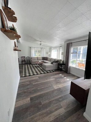 Relax in this stylish living room with a high ceiling, checkered floor, and large window.