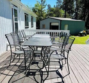 Eine überdachte Terrasse mit einem rechteckigen Tisch und Stühlen.