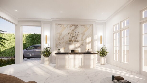 Zona de recepción de hotel con pared de mármol, mostrador de recepción y dos plantas en macetas.