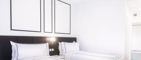 Habitación de hotel con dos camas, un diseño de techo moderno y piso de mármol.