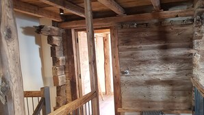 Ein Holzinnenraum mit Treppe, einer Bank und einer Holzreling.
