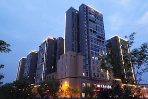 A high-rise building with multiple floors, large windows, and a flat roof. - Tongxilai Hotel (Jingyan)