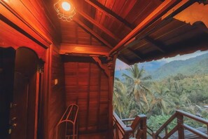 A wooden interior with a view of a tropical landscape. - Rostika Hotel Sekumpul (Sawan)