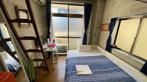A compact hotel room with a bed, a desk, and a ladder. - Quartier Blanc Yoga (Tokyo)