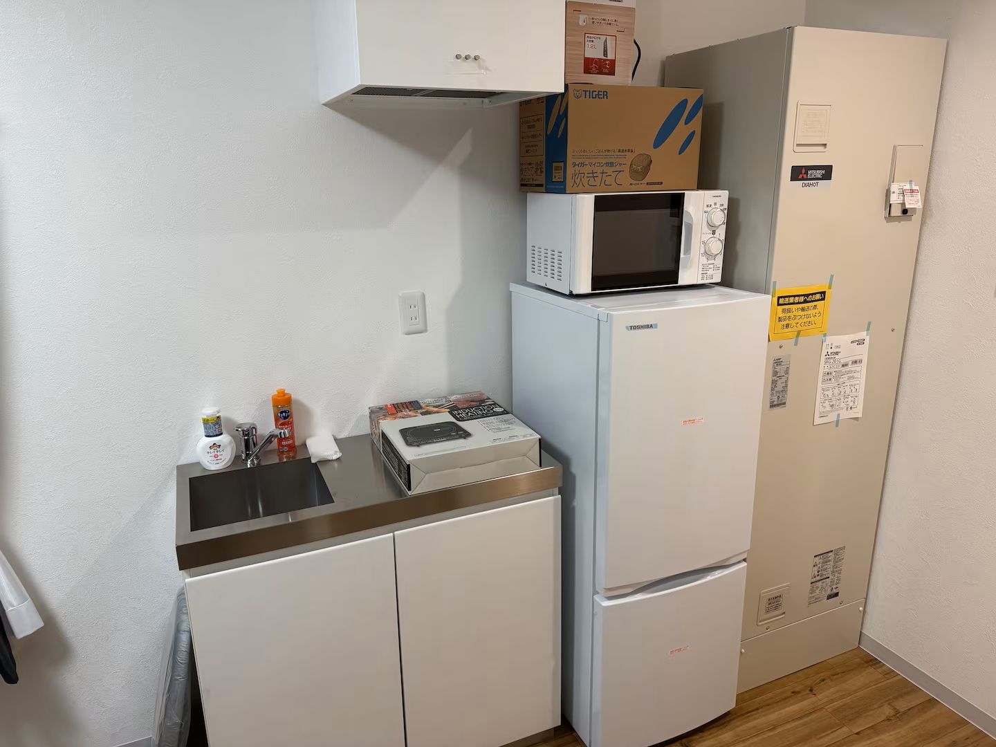 Eine kompakte Küche mit Mikrowelle, Kühlschrank und kleiner Arbeitsfläche.