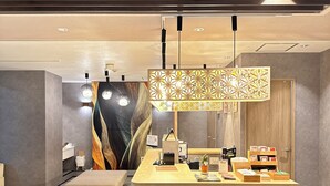 Una zona de recepción moderna con un escritorio de madera, un banco y un panel decorativo.