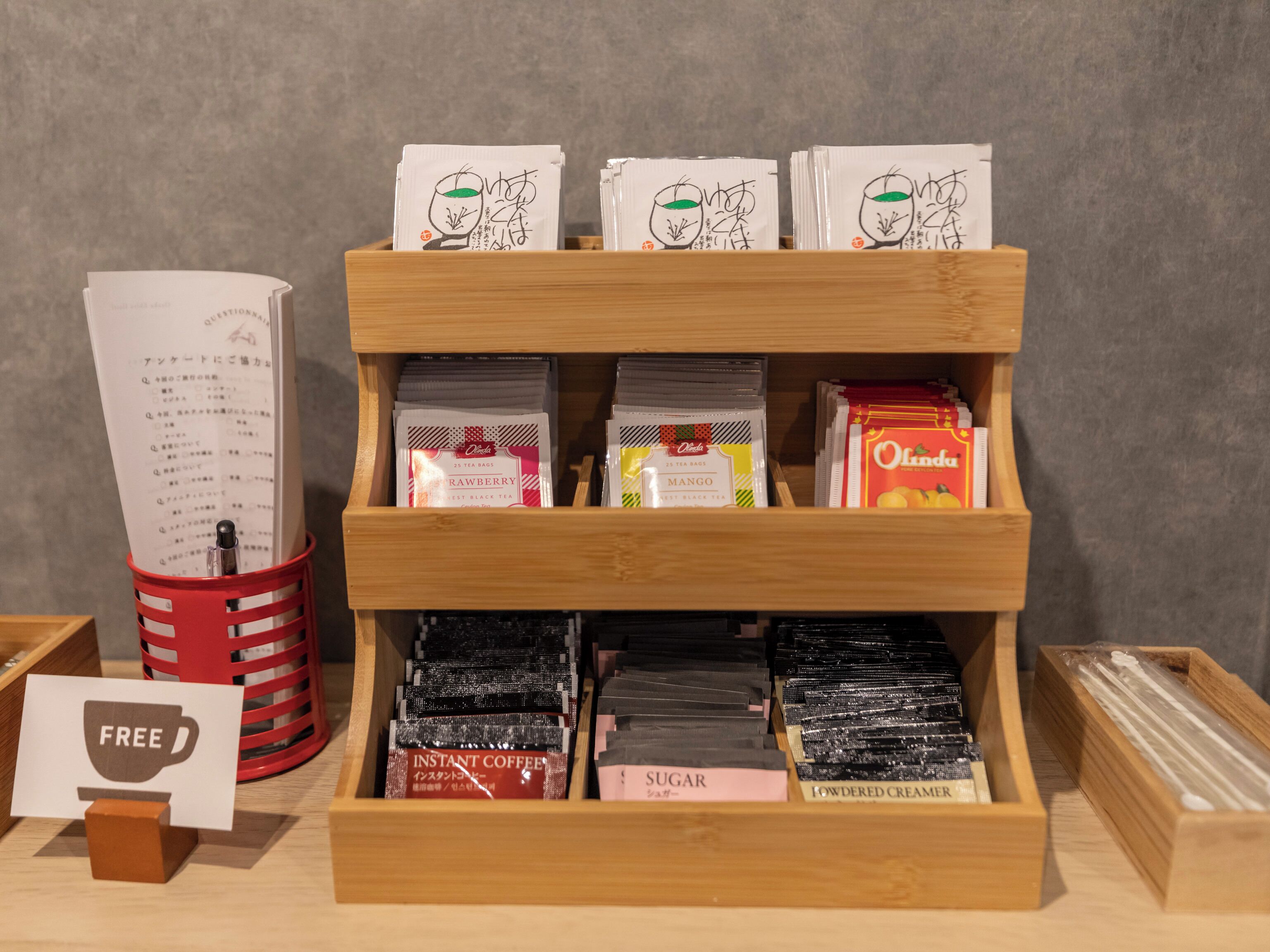 Una presentación de café instantáneo y bolsitas de té con etiquetas, todo dentro de una caja de madera.