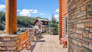 A wooden deck with stone walls and benches, leading to a lodge with a mountain view. - Meridian Magic-Fantastic 4BD home, Dog friendly (Skyland & Surrounding Areas)