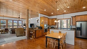 A spacious kitchen with wooden cabinets, a central island, and a large island with seating. - Meridian Magic-Fantastic 4BD home, Dog friendly (Skyland & Surrounding Areas)