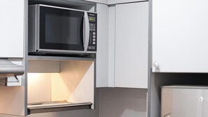 A kitchen with a stainless steel sink, a microwave, and a refrigerator. - Le Mansion Senopati Hotel (Jakarta)