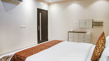 Una habitación de hotel con cama, cómoda, aire acondicionado y puerta.