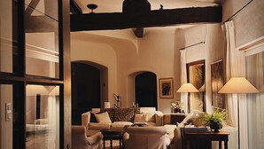 A cozy living room with a fireplace, comfortable seating, and a large window.