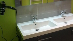 Une salle de bain avec deux lavabos, un miroir et un porte-serviettes.