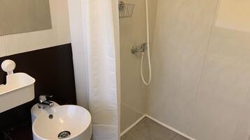 Chuveiro, toalhas de banho, sabonete, shampoo