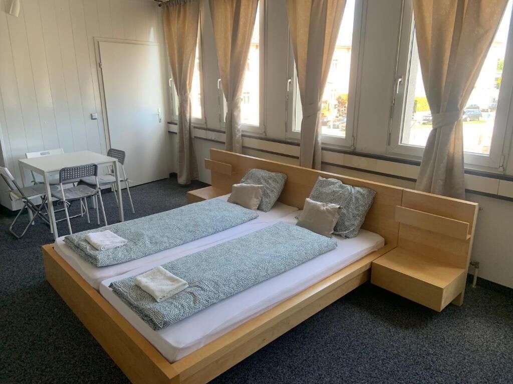 Una habitación con cama, una mesita y una silla.