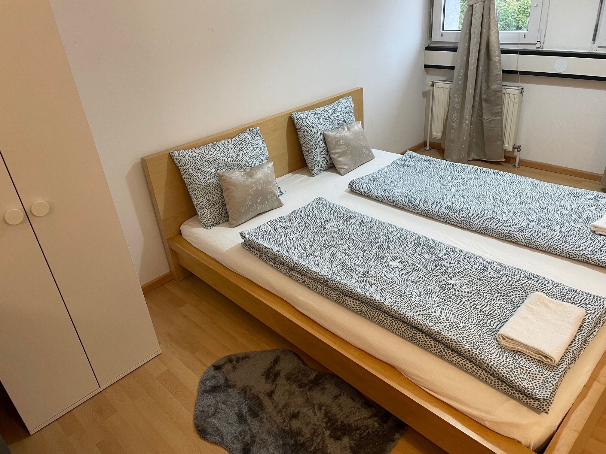 Ein kleines, gemütliches Schlafzimmer mit einem Einzelbett, einem Holzschrank und einer Heizung.