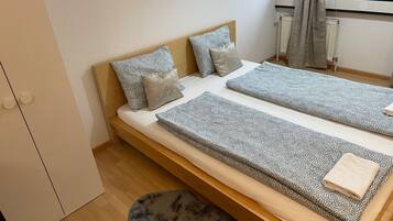 Ein kleines, gemütliches Schlafzimmer mit einem Einzelbett, einem Holzschrank und einer Heizung.