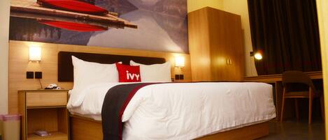 A hotel room with a bed, nightstands, a desk, and a chair.