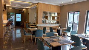 A modern restaurant with a bar area, seating arrangements, and a view through large windows. - Ivy Hotel Emerald (Lagos)