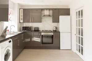 Uma cozinha moderna com eletrodomésticos de aço inoxidável, forno embutido e máquina de lavar louça.