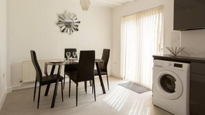 A dining area with a table, chairs, and a washing machine. - Immaculate 2-bed House in Dartford (Dartford)