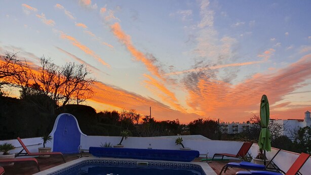 A swimming pool with lounge chairs and a blue water feature. - 3 Bedroom (Sleeps 7) Villa in Carvoeiro (Carvoeiro)