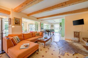 A spacious living area with a sofa, coffee table, and a large rug.