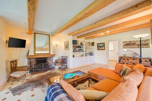 A living room with a fireplace, sofa, and bookshelves.