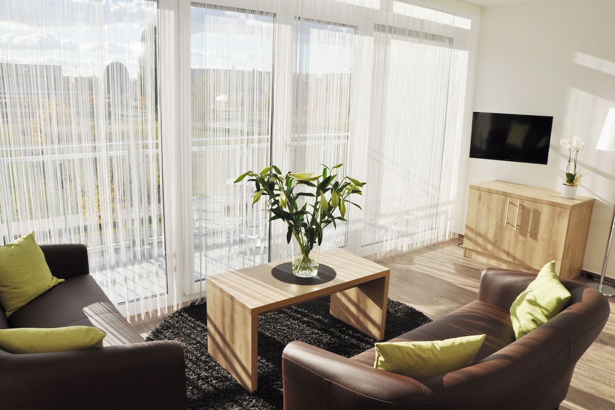 Una sala de estar moderna con un sofá, una mesa de centro y un televisor.