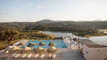 Een buitenzwembad, parasols voor strand/zwembad
