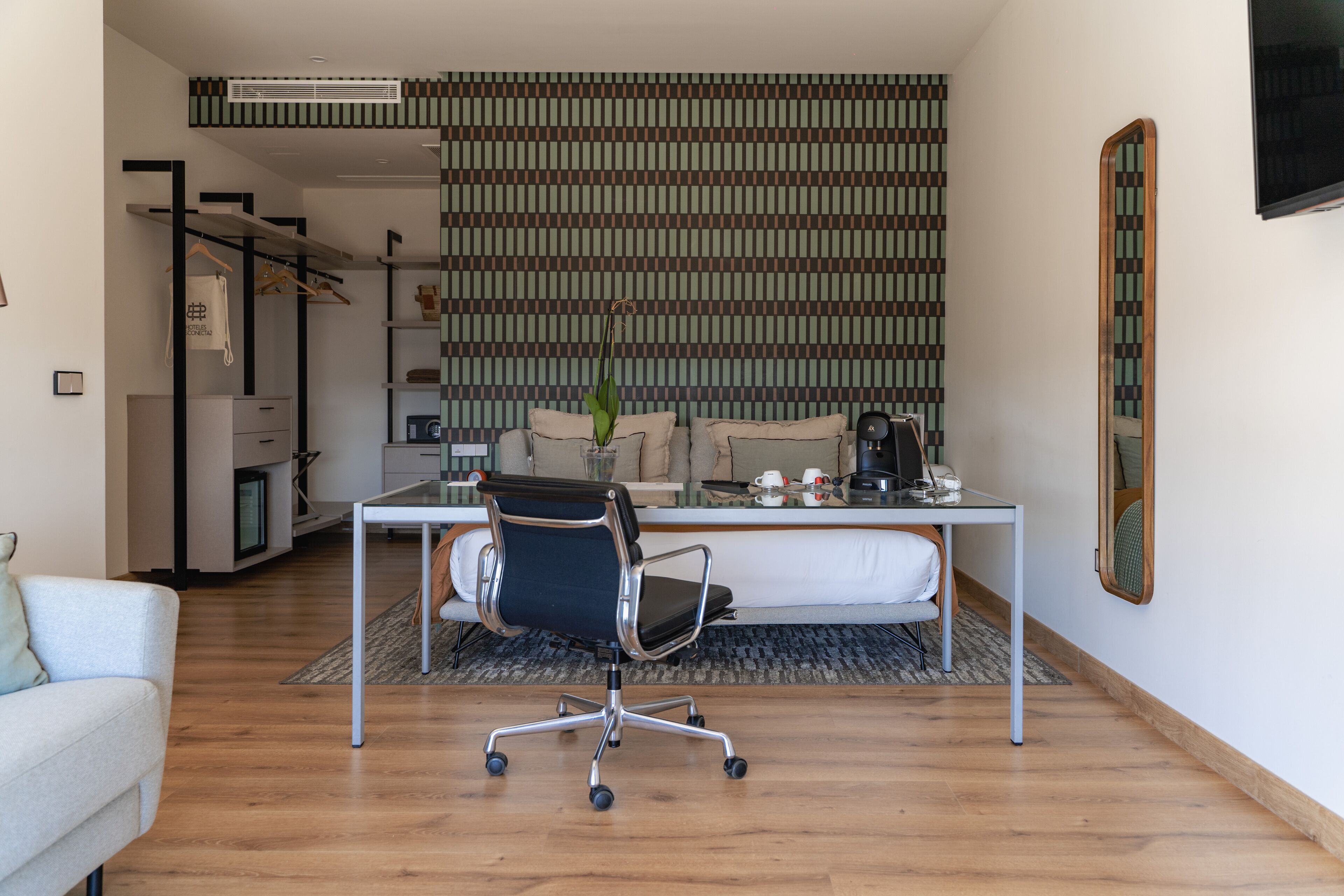 Een moderne kantoorruimte met een bureau, bureaustoel en een grote spiegel.