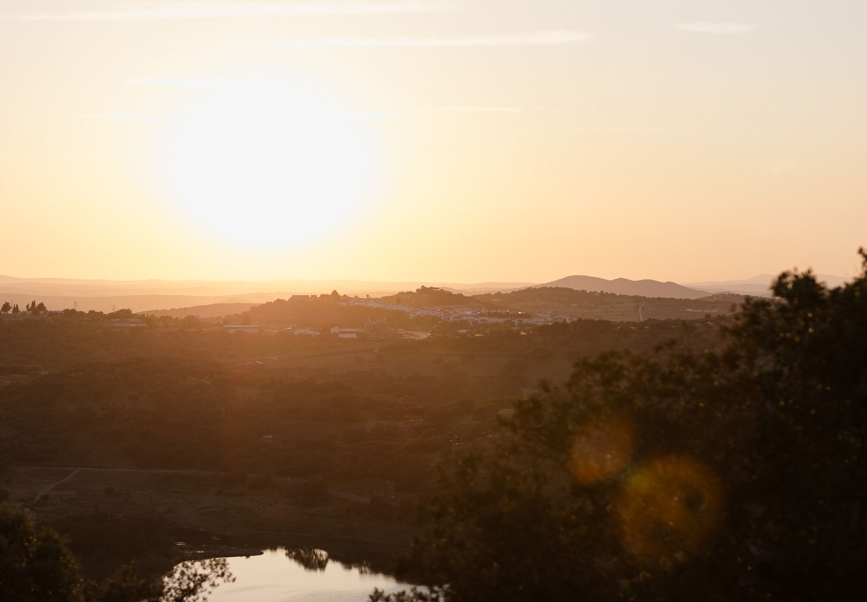 Una vista panorámica de un paisaje al atardecer con un horizonte lejano y colinas.