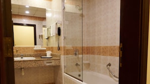 Un baño con lavabo, espejo y ducha con mampara de vidrio.