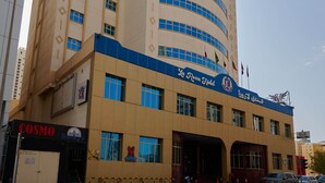 Un hotel con varios pisos, una entrada destacada y un cielo despejado.