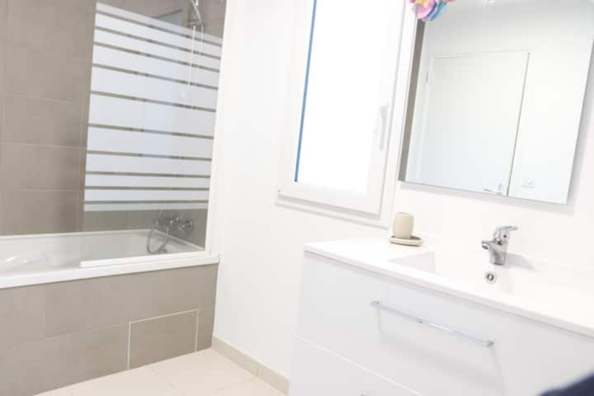 Een badkamer met een bad, een wastafel en een spiegel.