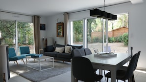 A modern living room with a sofa, chairs, a coffee table, and a dining table. - Maison, 5mn de Plage Lanséria, 4 à 10 Personnes (Mesquer)
