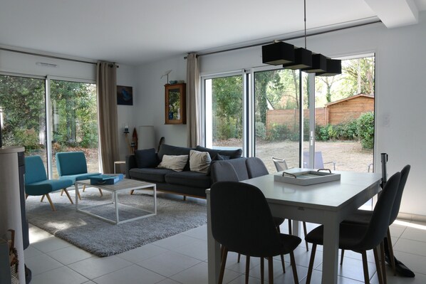 En moderne stue med sofa, stole, sofabord og spisebord.