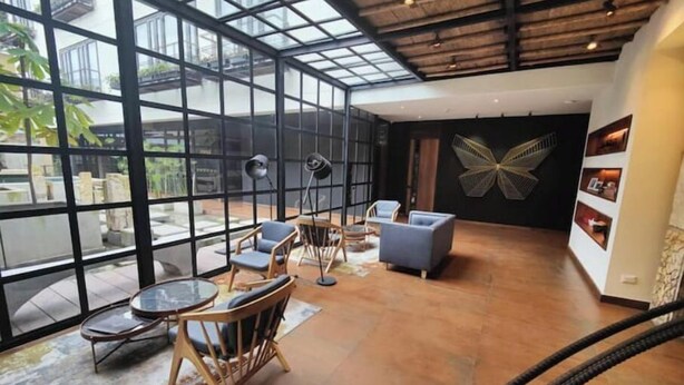 A spacious interior with a high ceiling, large windows, and a modern design. - R1/ Artistic loft in La Candelaria (Bogotá)