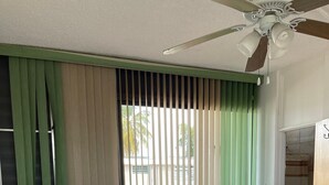 A bedroom with a bed, a ceiling fan, and a window with blinds. - Punta Salinas Oasis (Toa Baja)