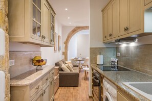 Enjoy cooking in this kitchen with a central island, stove, and oven, plus a cozy dining area with a sofa and chairs.
