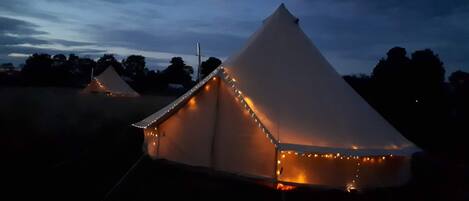 Una carpa con techo a dos aguas y luces decorativas a lo largo de los bordes.