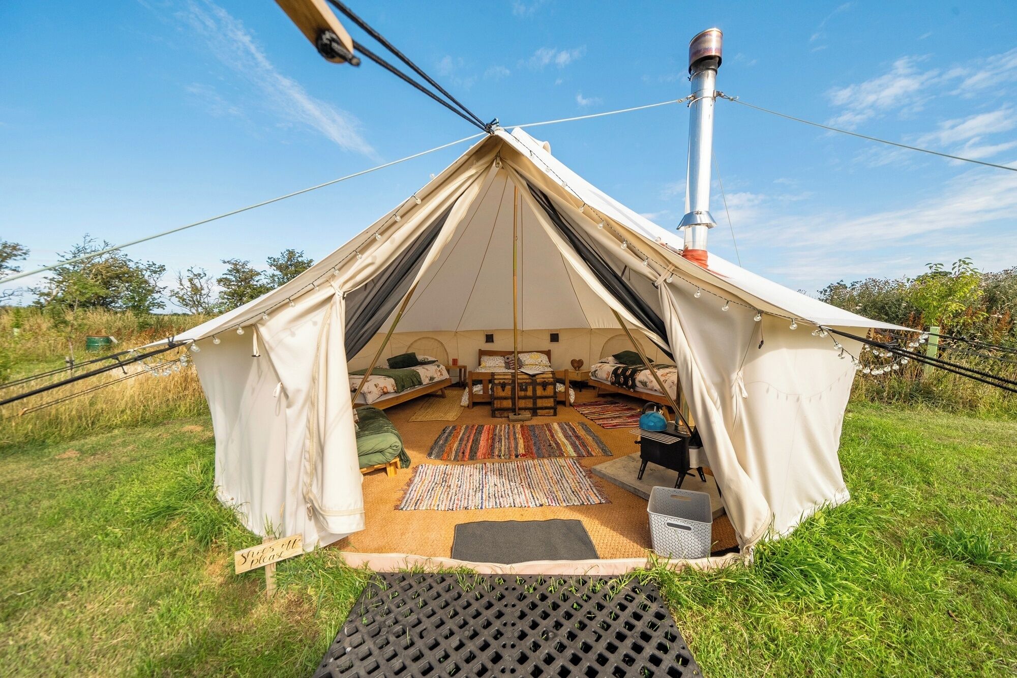 Uma tenda com uma cama, uma mesa e uma cadeira no interior.