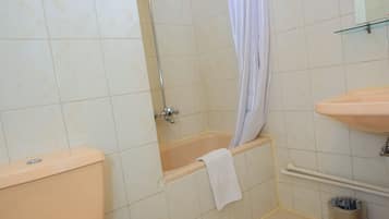 A bathroom with a toilet, bathtub, and sink.