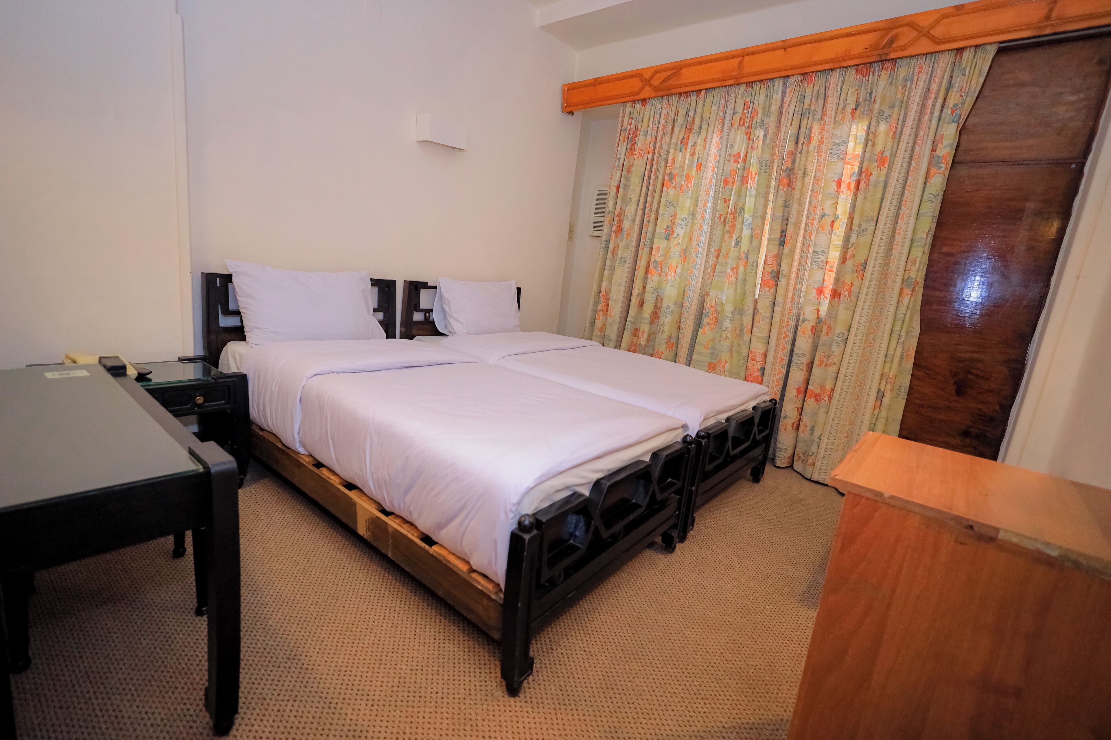 Ein Schlafzimmer mit einem Bett, einem Schreibtisch und einem Holz-Kopfteil.